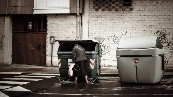 Mujer mayor buscando un cubo de basura