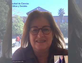 María Luisa Jalón, Decana de la Factultad de Ciencias Sociales y Jurídicas de la URJC, en videollamada durante la entrevista. De fondo, una imagen de facultad de la URJC en Vicálvaro.