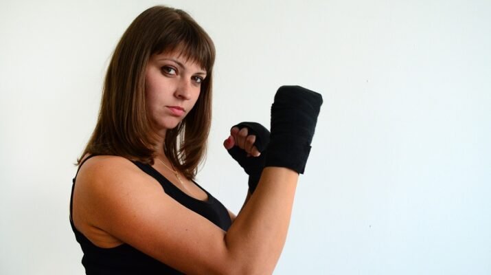 Mujer con guantes de lucha mirando desafiante a la cámara