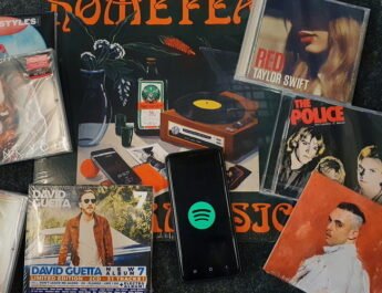 Disco de vinilo, discos CD de C Tangana, The Police, Taylor Swift, Harry Styles, Meghan Trainor, Britney Spears y David Guetta y un móvil con el símbolo de Spotify. Todos ellos superpuestos sobre una superficie oscura.