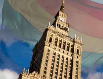 Montaje del Palacio de Cultura de Varsovia con la bandera LGTBI+ de fondo semitransparente en el cielo.