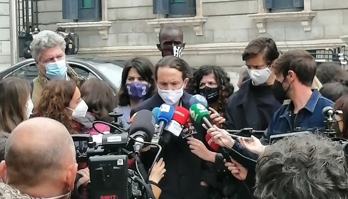 Pablo Iglesias declarando a la prensa, rodeado de micrófonos a las afueras del Congreso de los Diputados