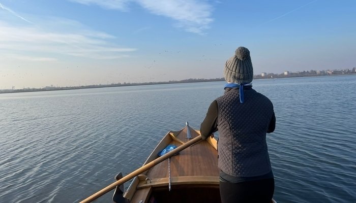 Una mujer con ropa deportiva maneja una embarcación en Venecia