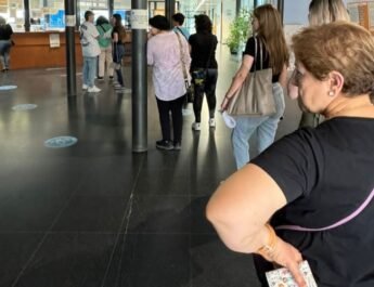 En la foto propuesta se aprecia una fila de personas para ser atendidas en un Hospital con ademanes de desesperación.